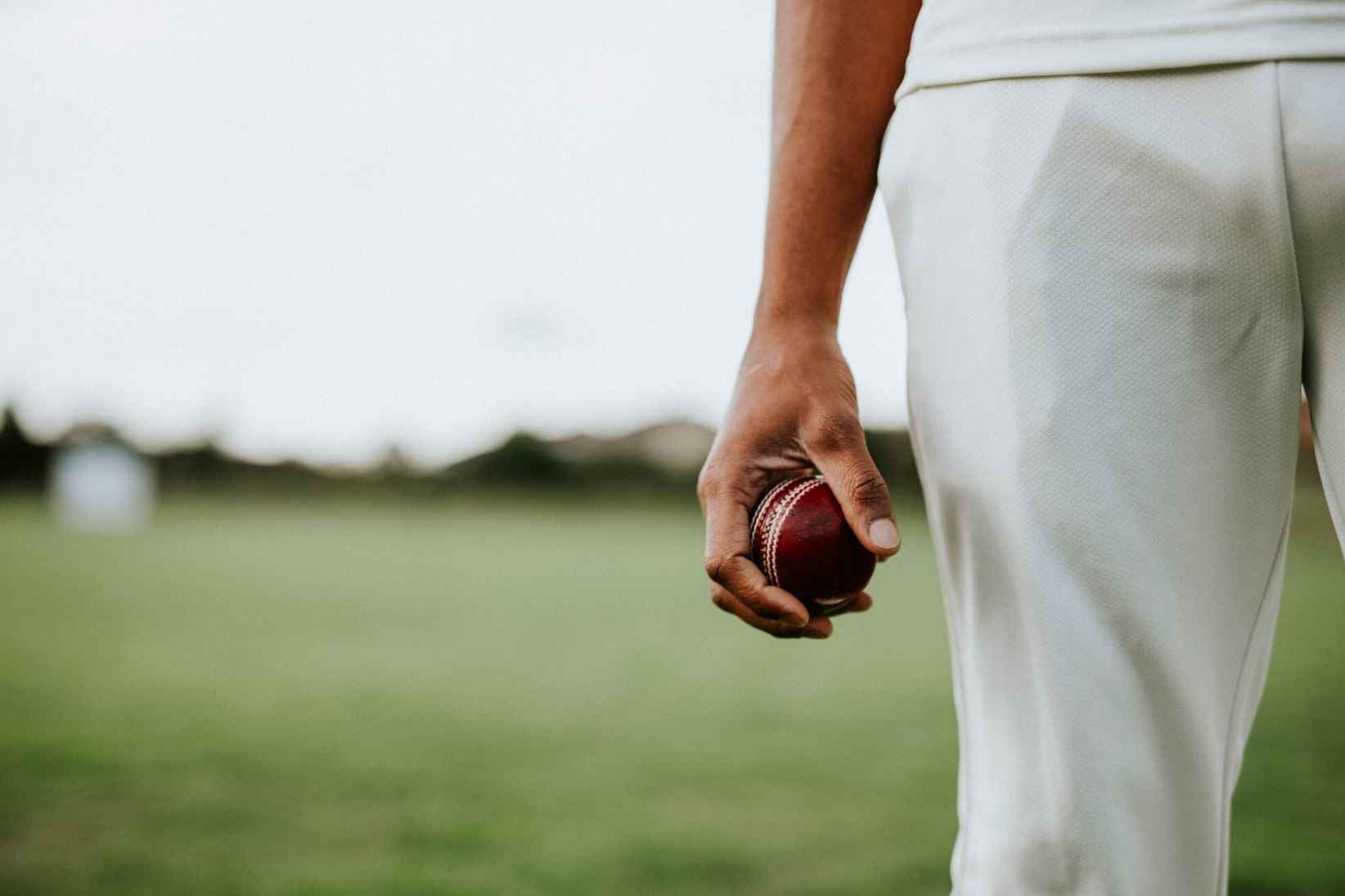 A man holds a cricket ball